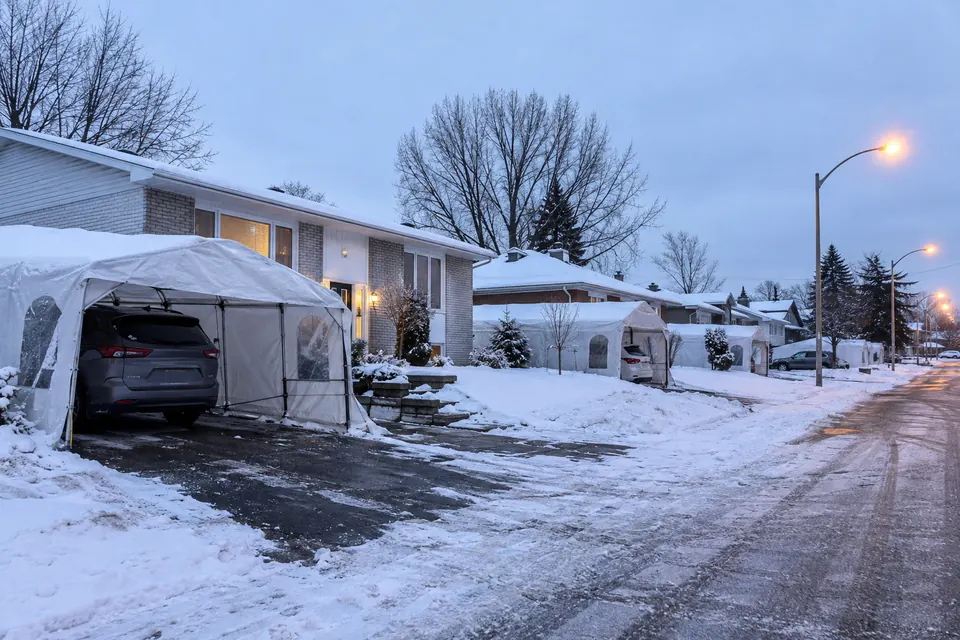 Rue de banlieue au Québec à l’aube, des abris Tempo dans les entrées après la première neige
